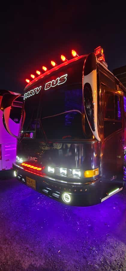 Medellin: Rumbero Party Bus with all the beer you can drink - Milla de Oro Avenue views: hotels, shopping centers, and night-city perspective